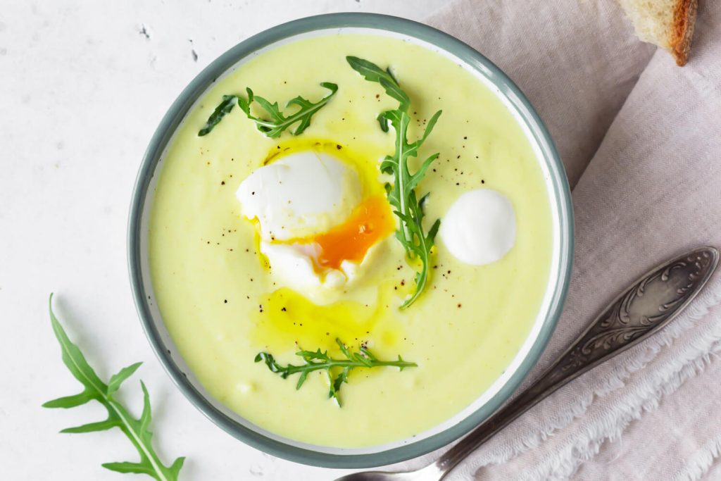 Blumenkohl-Cremesuppe mit pochiertem Ei, Olivenöl und Rucola