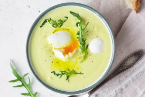 Blumenkohl-Cremesuppe mit pochiertem Ei, Olivenöl und Rucola