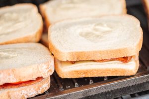 Gegrilltes Sandwich mit knusprigem Speck, Tomate und Käse