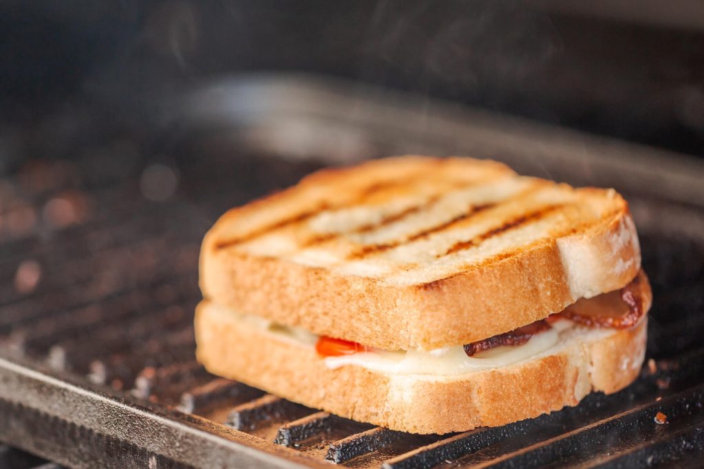 Gegrilltes Sandwich mit knusprigem Speck, Tomate und Käse