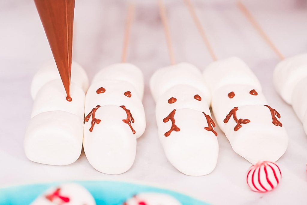 Marshmallow-Schneemänner und Rentiere am Stiel