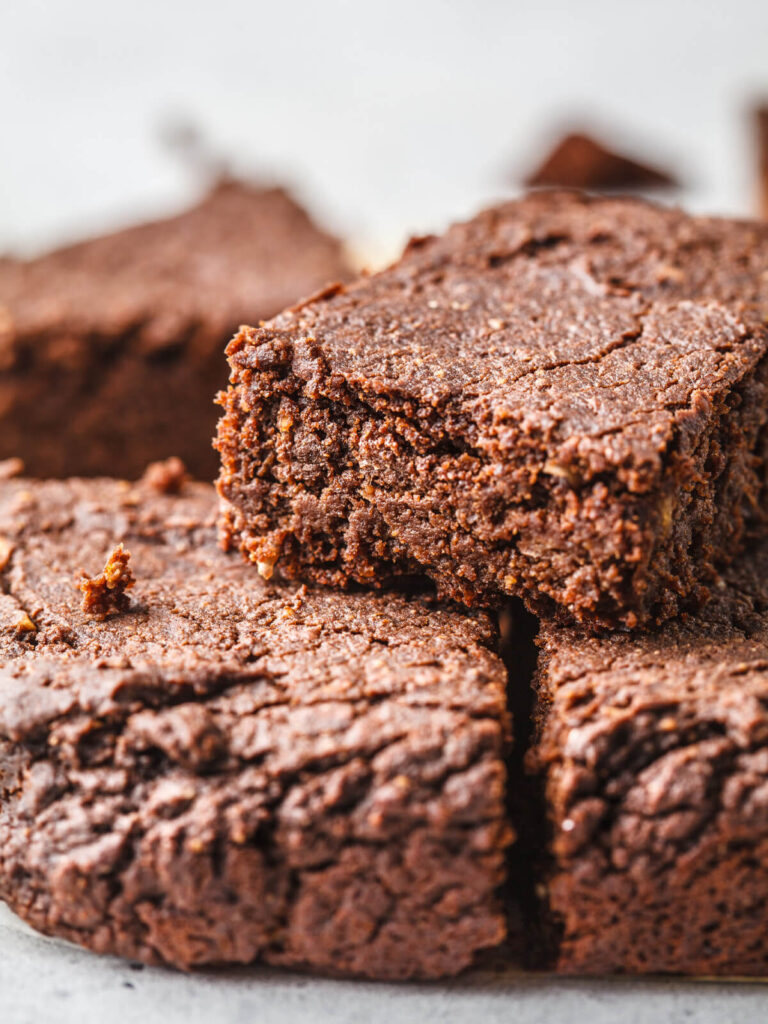 Weiße-Bohnen-Brownies – der gesündeste Schokogenuss aller Zeiten (vegan & ohne Zucker) I. KULINARISCHE PROVOKATION – EIN BROWNIE, DER ALLES ANDERS MACHT Wer das erste Mal hört, dass Brownies aus weißen Bohnen bestehen, reagiert oft mit einem Stirnrunzeln. Bohnen? In einem Dessert? Und doch: Diese kleinen weißen Proteinwunder machen die Brownies nicht nur unglaublich saftig, sondern auch nährstoffreich und völlig ohne herkömmliches Mehl oder Zucker. Das Ergebnis? Eine „fudgy“, schokoladige Konsistenz, die kein Mensch jemals mit Hülsenfrüchten in Verbindung bringen würde – ein echtes Aha-Erlebnis. Diese Brownies sind nicht nur vegan, sondern passen perfekt in jede Clean-Eating- und High-Protein-Ernährung. Sie liefern natürliche Energie, halten lange satt und stillen gleichzeitig das Verlangen nach Süßem – ganz ohne Reue. ⸻ II. DER STAR DES REZEPTS – WARUM WEISSE BOHNEN DIE IDEALE BASIS SIND Weiße Bohnen übernehmen gleich mehrere Aufgaben in diesem Rezept. Einerseits sorgen sie für die berühmte, dichte Brownie-Textur – „fudgy“ statt trocken. Das feine Bohnenpüree ersetzt einen großen Teil von Mehl und Fett, was die Brownies gleichzeitig cremig und saftig macht. Andererseits bringen Bohnen wertvolles pflanzliches Eiweiß und Ballaststoffe ins Spiel. Das sorgt nicht nur für eine langanhaltende Sättigung, sondern stabilisiert auch den Blutzuckerspiegel. Der wichtigste Tipp: Die Bohnen müssen gründlich abgespült und anschließend zu einem absolut glatten Püree verarbeitet werden – keine Stückchen, keine Körnigkeit. Nur so entsteht das samtige Mundgefühl, das den Brownies ihre fast „mousseartige“ Konsistenz gibt. ⸻ III. DIE KUNST DES CLEAN BAKINGS – WENIGER IST MEHR Die Magie dieser Brownies liegt in der Kombination natürlicher Zutaten, die perfekt zusammenarbeiten. Das Leinsamen-Ei (1 EL gemahlene Leinsamen + 3 EL Wasser) ersetzt das klassische Ei. Es bindet die Masse, sorgt für Stabilität und liefert zusätzlich Omega-3-Fettsäuren. Der Kokosblütenzucker verleiht eine milde, karamellige Süße – ganz ohne Blutzuckerspitzen. In Kombination mit Kokosöl und Erdnussmus entsteht der typische Brownie-Schmelz: reichhaltig, aber nicht schwer. Das Backgeheimnis liegt in der Balance: Die Brownies dürfen nicht zu lange gebacken werden. Wenn das Holzstäbchen beim Testen noch leicht feucht herauskommt, ist das genau richtig – das Innere bleibt saftig, das Äußere bekommt eine zarte Kruste. Und dann kommt der entscheidende Moment: das Abkühlen. Erst nach etwa zwei Stunden im Kühlschrank entfalten die Brownies ihre ganze Kraft – dichter, schokoladiger, fast wie Pralinen in Kuchenform. ⸻ IV. VARIATIONEN UND PERFEKTE KOMBI Diese Brownies sind eine Leinwand für unzählige Ideen. Ein Klecks Johannisbeermarmelade oder ein paar frische Himbeeren bringen Frische und leichte Säure ins Spiel – perfekt als Kontrast zum tiefen Schokoladengeschmack. Wer es proteinreicher mag, gibt beim Servieren einen Löffel Erdnussbutter obendrauf. Das schmeckt nicht nur himmlisch, sondern liefert auch ein Extra an Energie – ideal nach dem Workout oder als Snack für den Nachmittag. Ein Hauch Meersalz oder eine Prise Chili macht die Brownies erwachsener, während gehackte Nüsse oder Schokodrops sie in Richtung Dessertklassiker verschieben. ⸻ V. FAZIT – EIN SUPERSMARTER DESSERT-HACK Diese Brownies sind der Beweis: Gesunde Ernährung muss nichts mit Verzicht zu tun haben. Mit nur wenigen Zutaten entsteht ein Dessert, das gleichzeitig schokoladig, nährstoffreich, glutenfrei, vegan und zuckerfrei ist. Ein Kuchen, der schmeckt wie Sünde – aber eigentlich ein Superfood ist. ⸻ 🍫 Auch probieren: Vegane Clean-Eating-Desserts, die süß und gesund zugleich sind 👉 Gefüllte Datteln mit Erdnussbutter & Pistazien (vegan, ohne Zucker) – cremig, nussig und natürlich süß – der perfekte Ersatz für Schokoriegel. 👉 Energiekugeln mit Kichererbsen und Erdnussbutter – proteinreich und ideal für den kleinen Hunger zwischendurch. 👉 Erdnuss-Pralinen mit Schokolade (vegan & ohne Zucker) – schmecken wie Mini-Snickers, aber in gesunder Form. 👉 Energy Balls mit Datteln & Erdnussbutter (roh & vegan) – süß, sättigend und voller Energie – ganz ohne Backen. 👉 Gefrorene Schoko-Bananen am Stiel (vegan & ohne Zucker) – knusprig, cremig, sommerlich frisch.