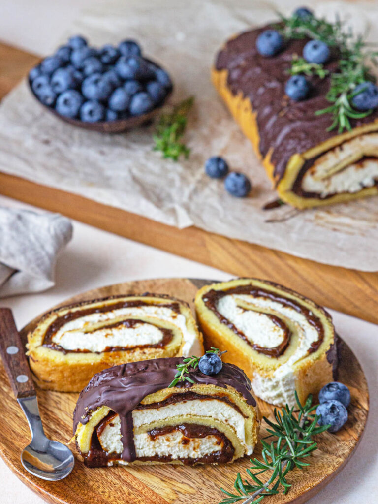 Biskuitrolle mit Pflaumen, Frischkäsecreme und Schokoladen-Drip