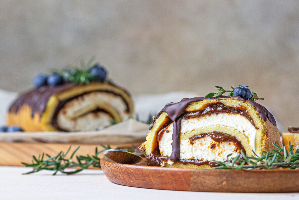 Biskuitrolle mit Pflaumen, Frischkäsecreme und Schokoladen-Drip