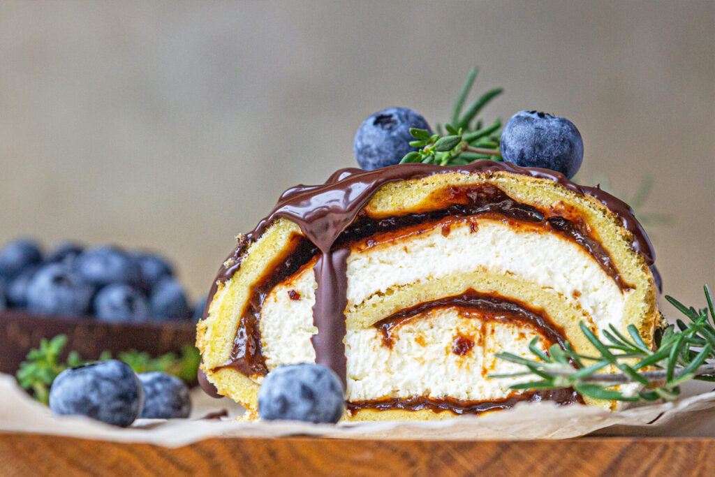 Biskuitrolle mit Pflaumen, Frischkäsecreme und Schokoladen-Drip