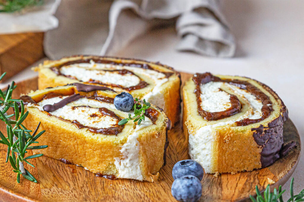 Biskuitrolle mit Pflaumen, Frischkäsecreme und Schokoladen-Drip