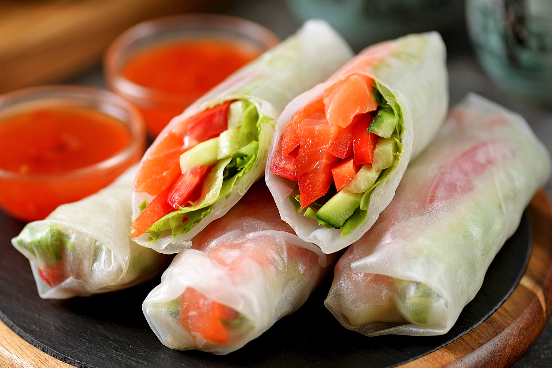 Aufgeschnittene Reispapierrollen mit Lachs und Gemüse