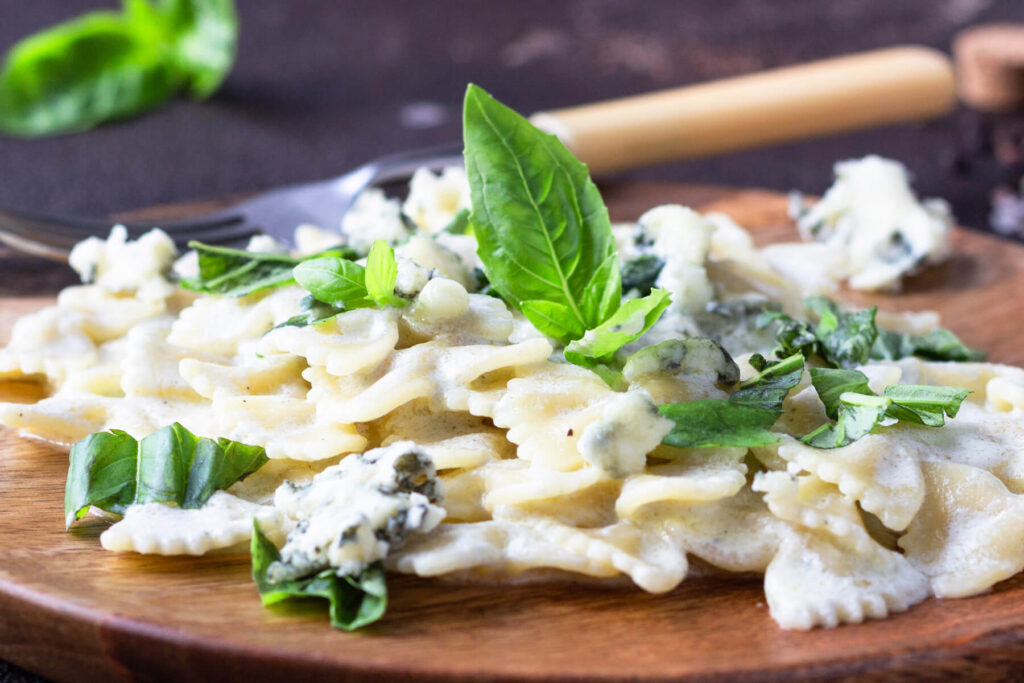 Pasta Farfalle in cremiger Blauschimmelkäse-Sauce mit frischem Basilikum