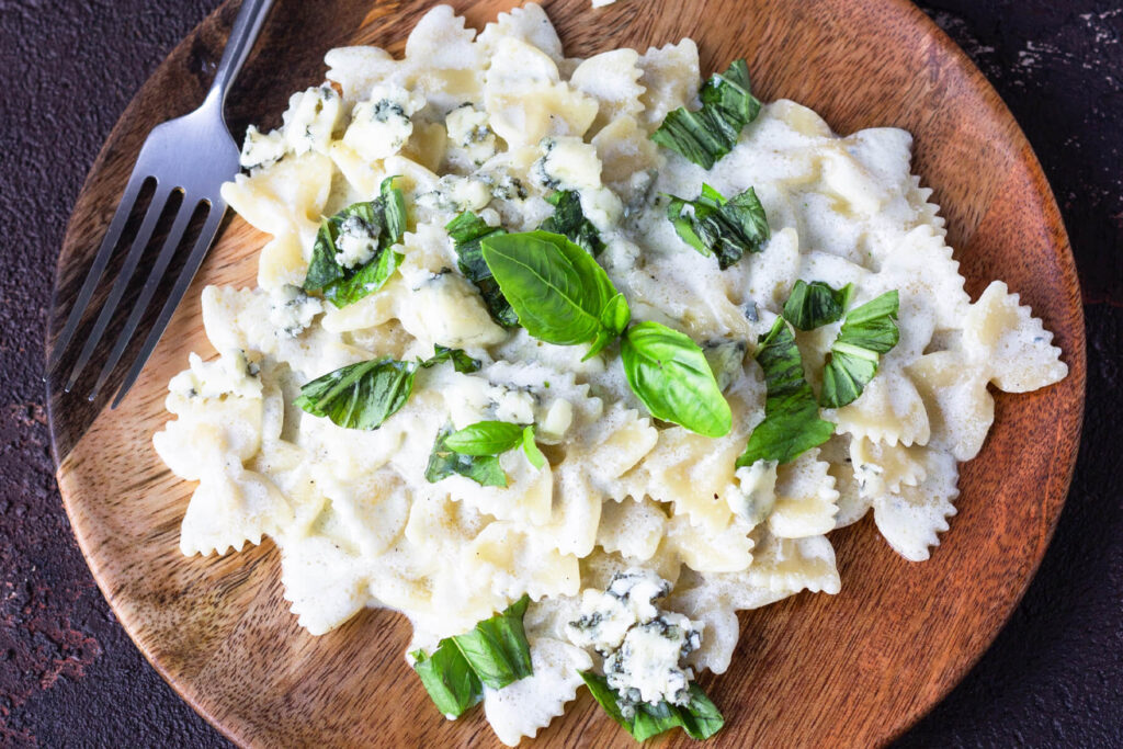 Pasta Farfalle in cremiger Blauschimmelkäse-Sauce mit frischem Basilikum