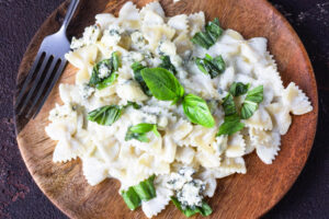 Pasta Farfalle in cremiger Blauschimmelkäse-Sauce mit frischem Basilikum