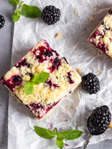 Zitronen-Cheesecake-Schnitten mit schwarzen Johannisbeeren & Streuseln