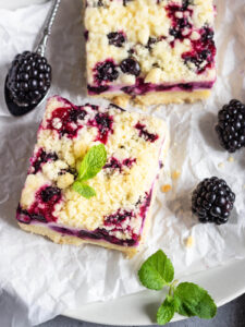 Zitronen-Cheesecake-Schnitten mit schwarzen Johannisbeeren & Streuseln