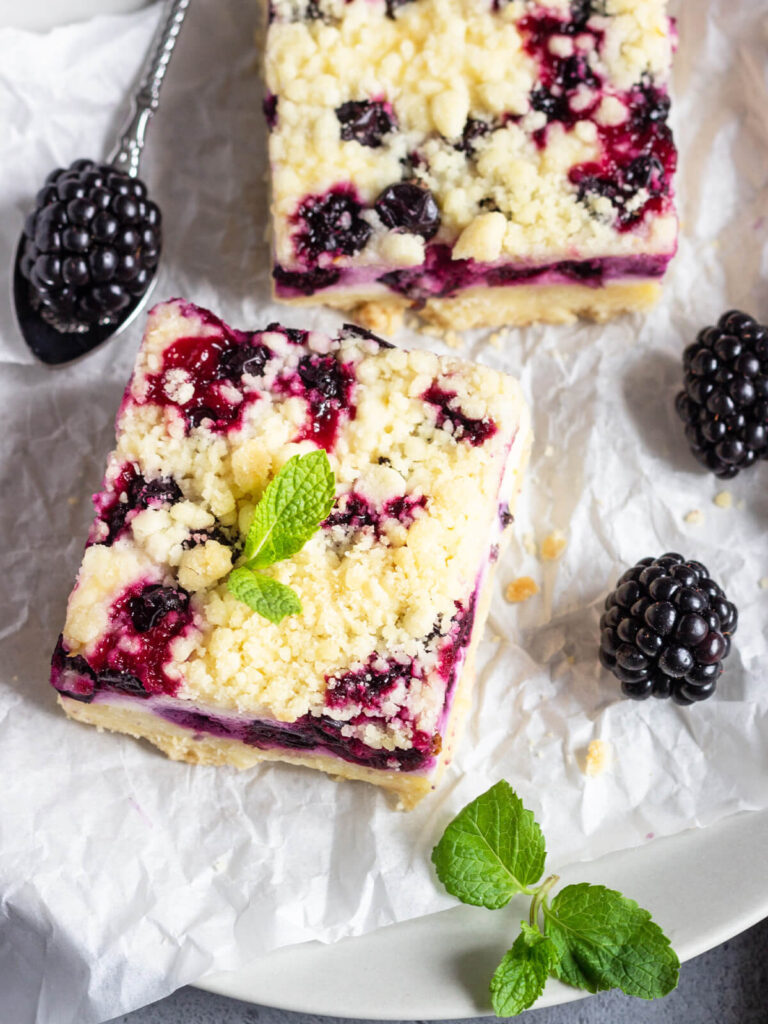 Zitronen-Cheesecake-Schnitten mit schwarzen Johannisbeeren & Streuseln