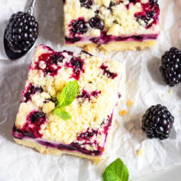 Zitronen-Cheesecake-Schnitten mit schwarzen Johannisbeeren & Streuseln