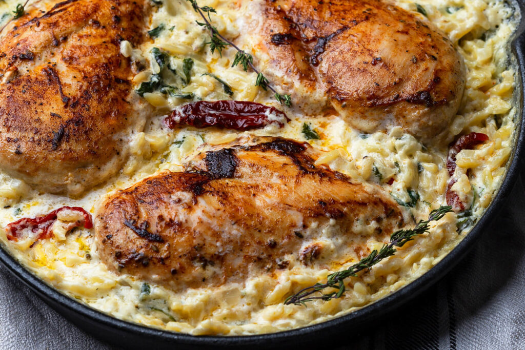 Orzo-Pasta mit Hähnchenbrust – Cremige Risoni-Pfanne mit Spinat, getrockneten Tomaten und Parmesan aus dem Ofen