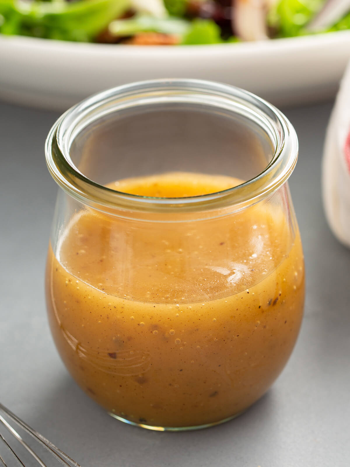 Nahaufnahme der Apfel-Vinaigrette im Glas mit goldener Emulsion