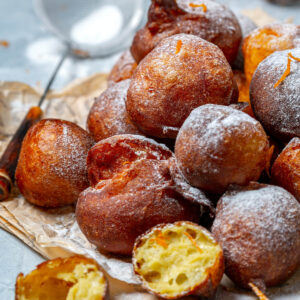Goldbraune Beignets mit Puderzucker bestäubt auf Teller