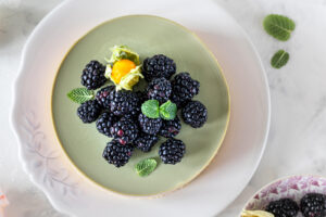 Brombeer-Matcha-Cheesecake von oben mit Brombeeren und Minze