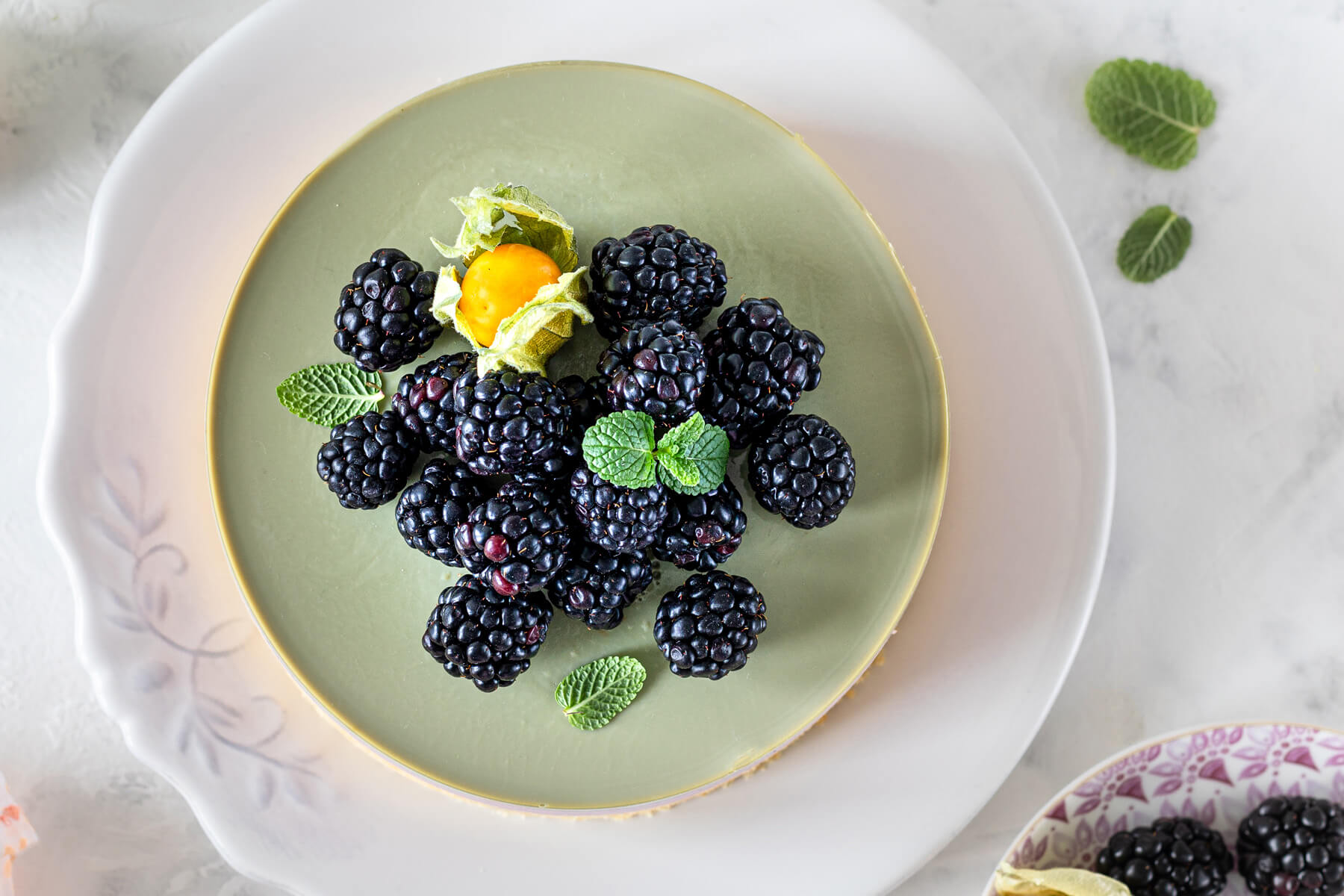 Brombeer-Matcha-Cheesecake von oben mit Brombeeren und Minze