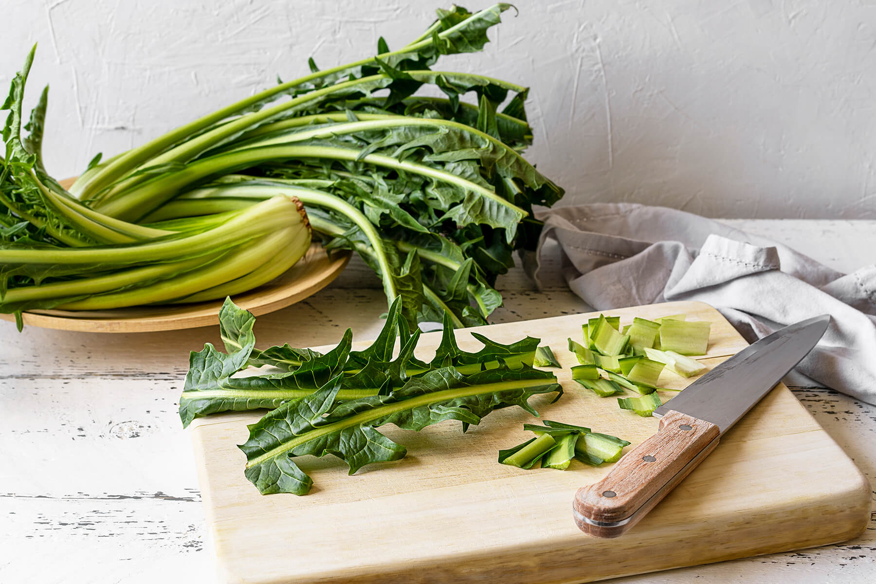 Frische Zikorieblätter und Knoblauchzehen vor der Zubereitung