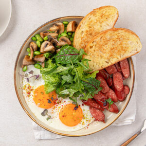English Breakfast Bowl mit Spiegelei, Würstchen und Salat