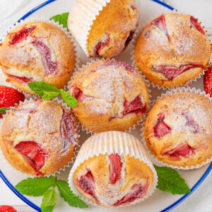 Erdbeer-Muffins auf Teller mit frischen Erdbeeren