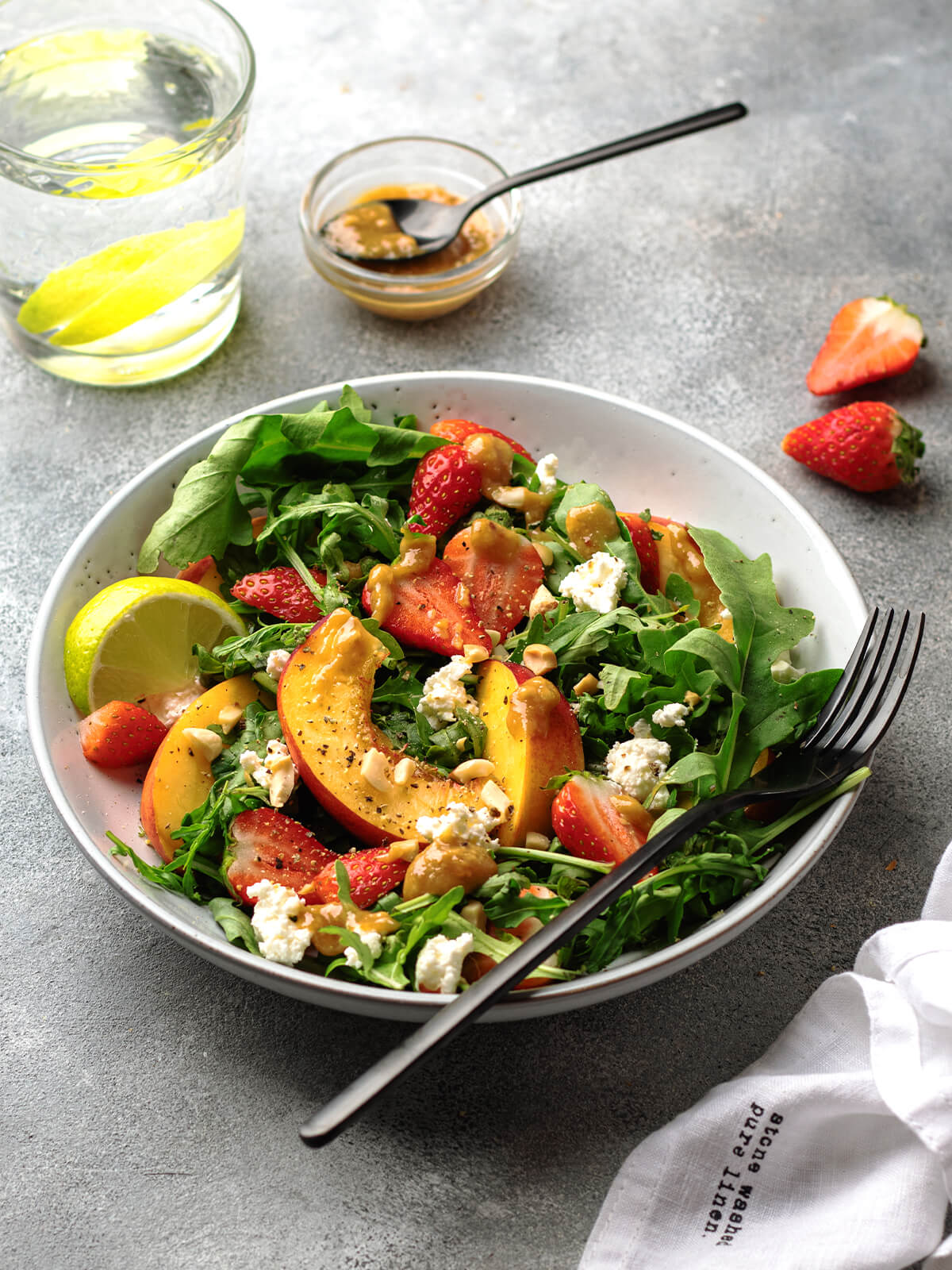 Erdbeer-Nektarine-Salat mit angebratenen Nektarinen, Erdbeeren und Erdnussbutter-Dressing auf einem hellen Teller