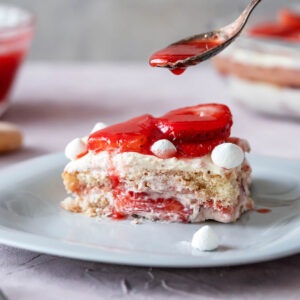 Erdbeer-Tiramisu mit frischen Erdbeeren und kleinen Baiser-Tupfen, geschichtet in einer Glasform