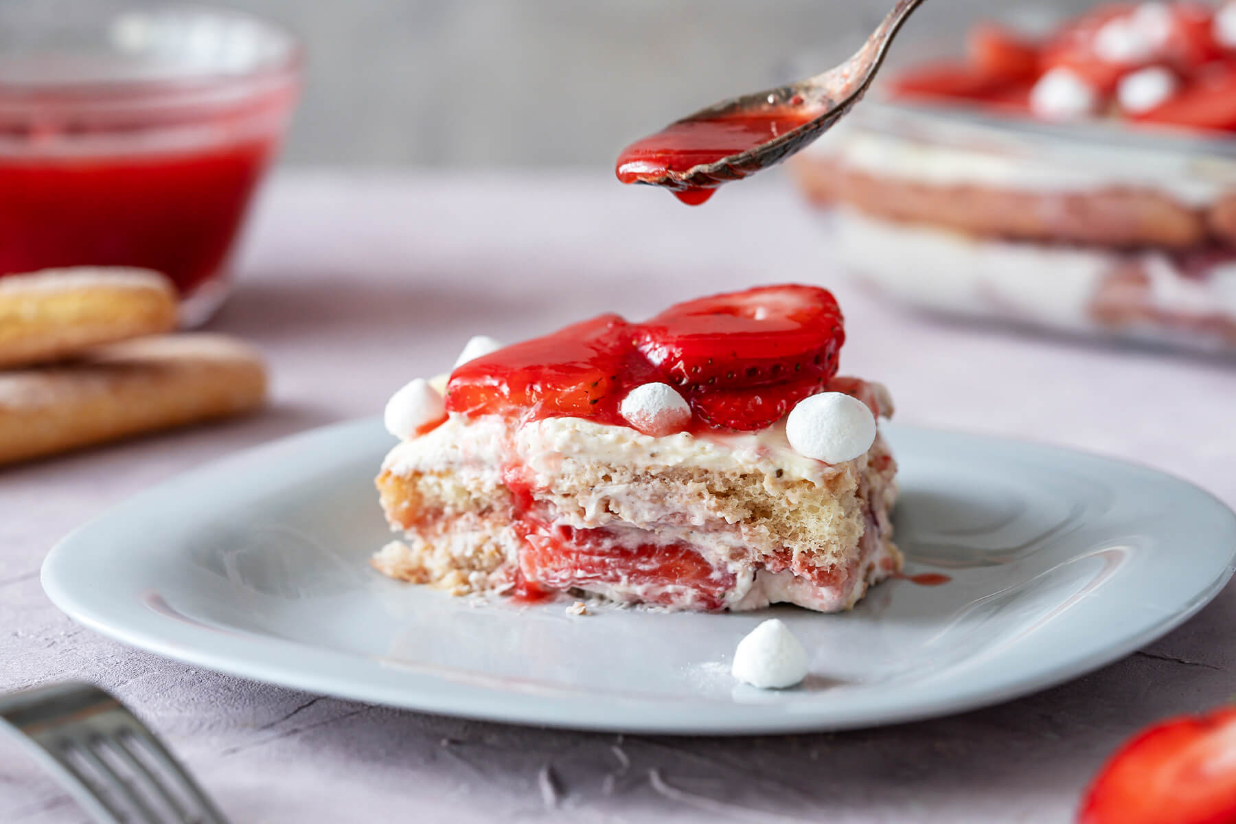 Erdbeer-Tiramisu mit frischen Erdbeeren und kleinen Baiser-Tupfen, geschichtet in einer Glasform