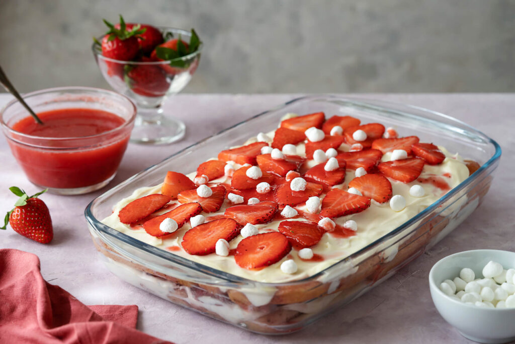 Erdbeer-Tiramisu mit frischen Erdbeeren und kleinen Baiser-Tupfen, geschichtet in einer Glasform