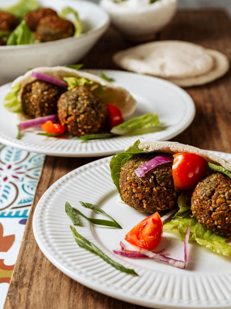 Zwei mit Falafel, Romana-Salat, Cherrytomaten und roten Zwiebelringen gefüllte Pita-Taschen
