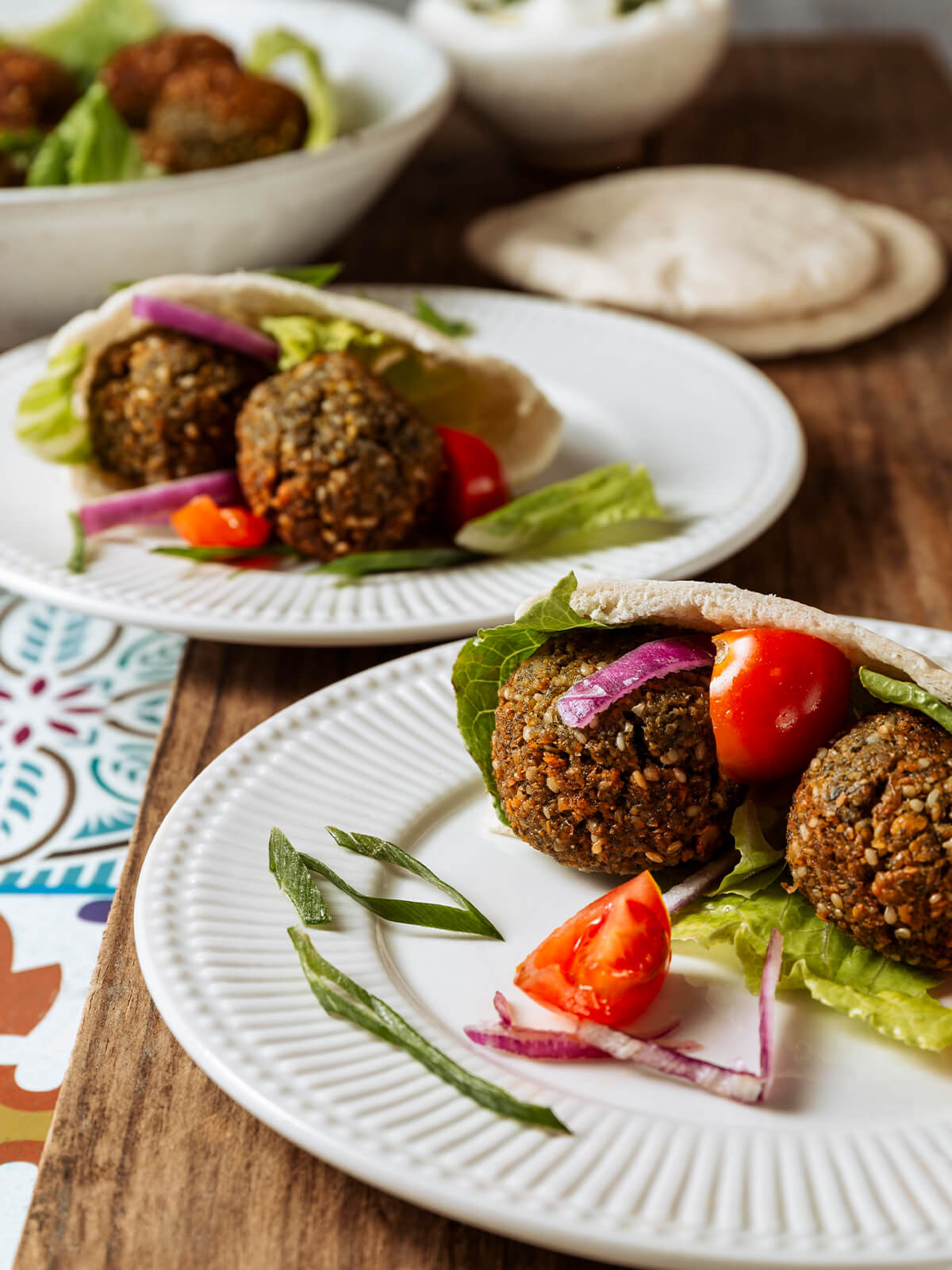 Zwei mit Falafel, Romana-Salat, Cherrytomaten und roten Zwiebelringen gefüllte Pita-Taschen