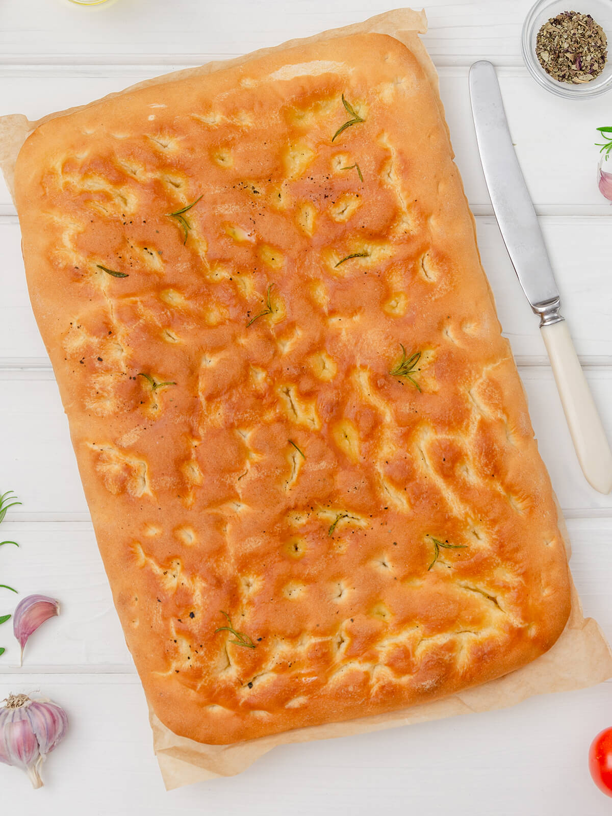 Klassische italienische Focaccia mit Rosmarin und schwarzem Pfeffer, goldbraun vom Blech