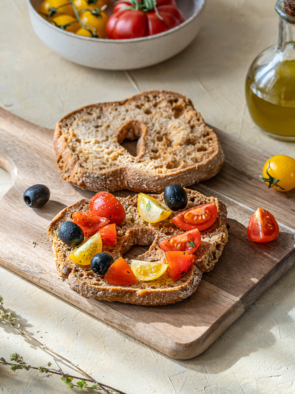 Apulische Friselle Pugliesi mit Kirschtomaten, schwarzen Oliven und Olivenöl auf Holzbrett – original italienisches Antipasto aus Puglia