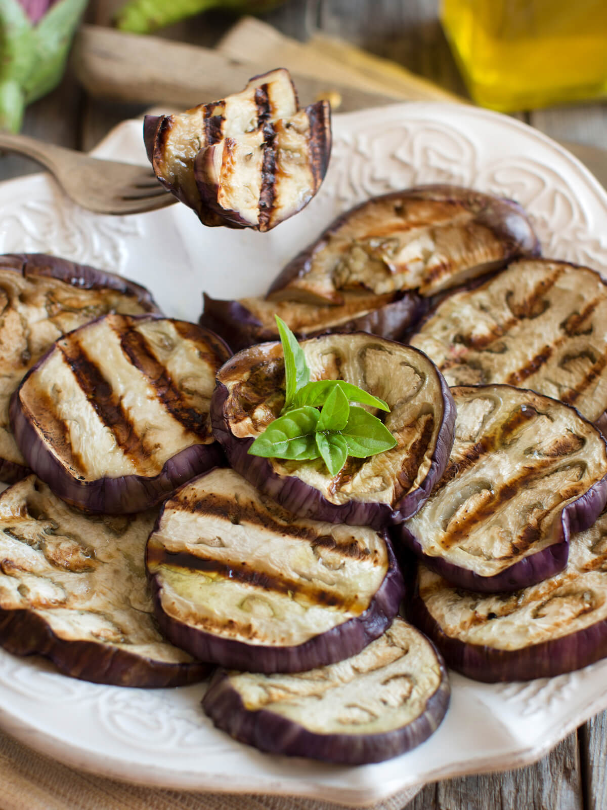 Gegrillte Auberginen mit Olivenöl, Grillstreifen und frischem Basilikum