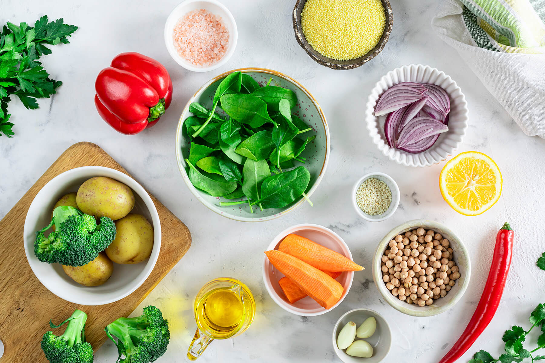 Zutaten für die Gemüse-Bowl von oben – Paprika, Babyspinat, Kartoffeln, Brokkoli, Möhren, Kichererbsen, rote Zwiebel, Couscous, Zitrone, Knoblauch, Olivenöl und Gewürze