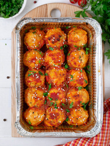 Hähnchen-Bällchen in Tomatensauce mit weißem und schwarzem Sesam und Petersilie