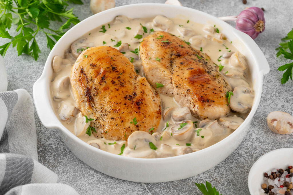 Hähnchenbrust in Pilz-Sahne-Sauce in weißer Keramikform