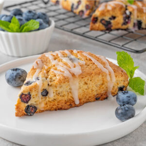 Heidelbeer-Scone auf Teller mit frischen Beeren