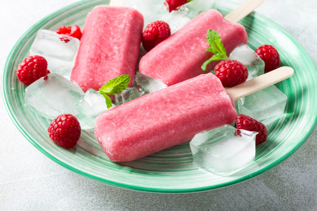 Frische und gefrorene Beeren mit dem Stieleis und Crushed Ice auf einem Tablett