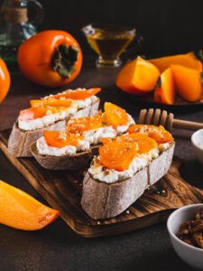 Kaki-Ricotta-Bruschetta Nahaufnahme mit Honig