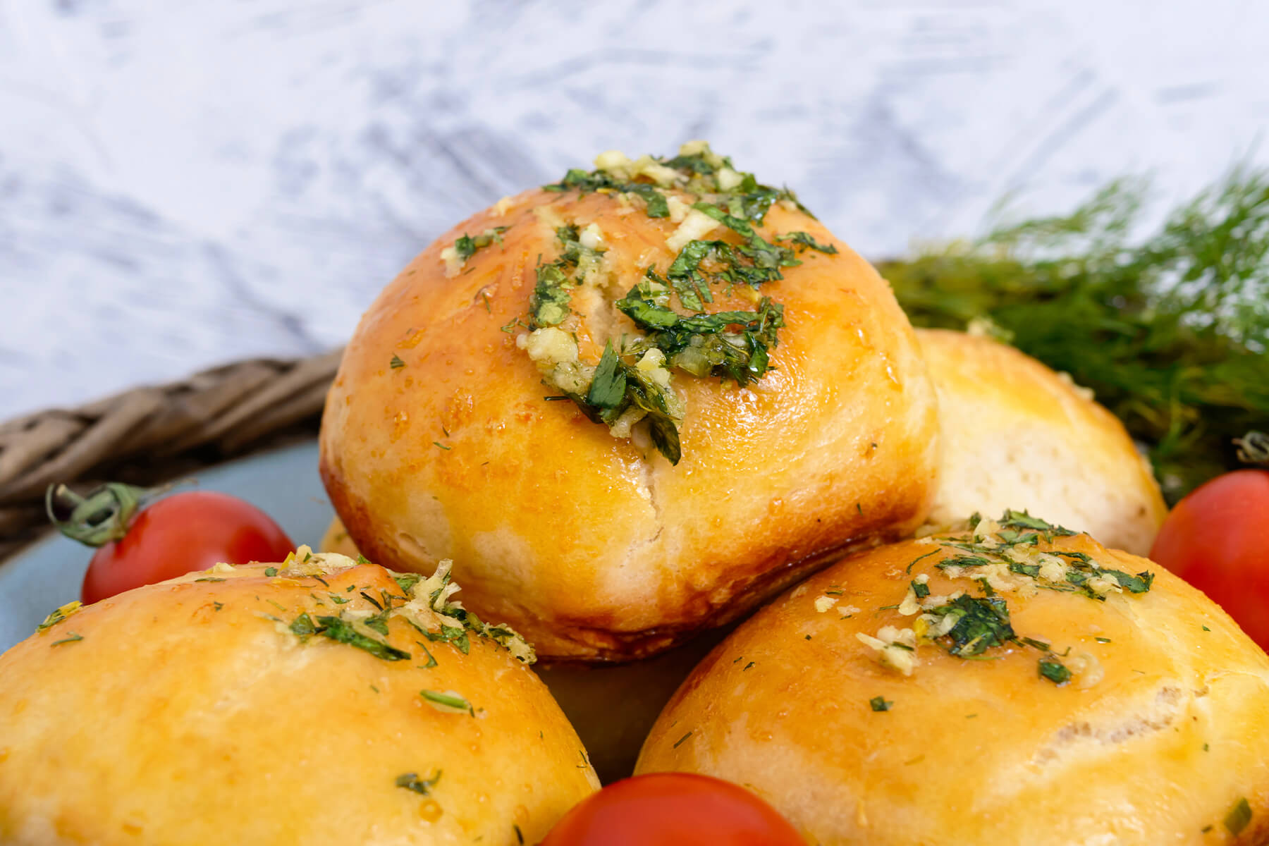 Knoblauch-Pampuschki Nahaufnahme mit Knoblauch-Kräuter-Öl, Dill und Kirschtomaten