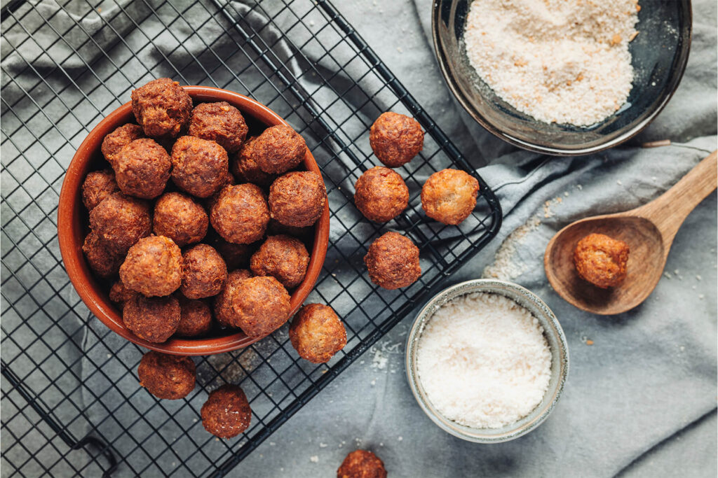 Detailaufnahme der goldbraun frittierten Polpette-Kugeln, knusprige Textur sichtbar