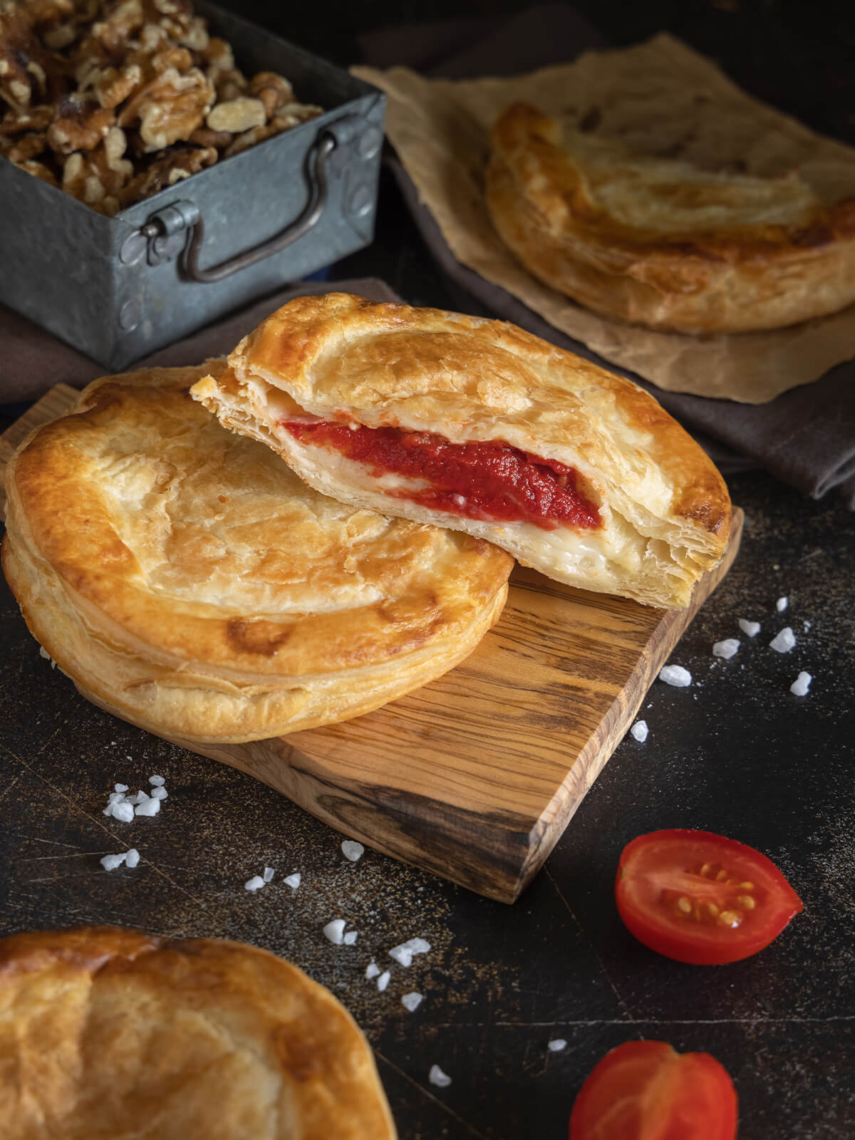 Aufgebrochenes Rustico Leccese mit dicker roter Tomatenschicht und cremiger Käseschicht auf dünnem Blätterteigboden
