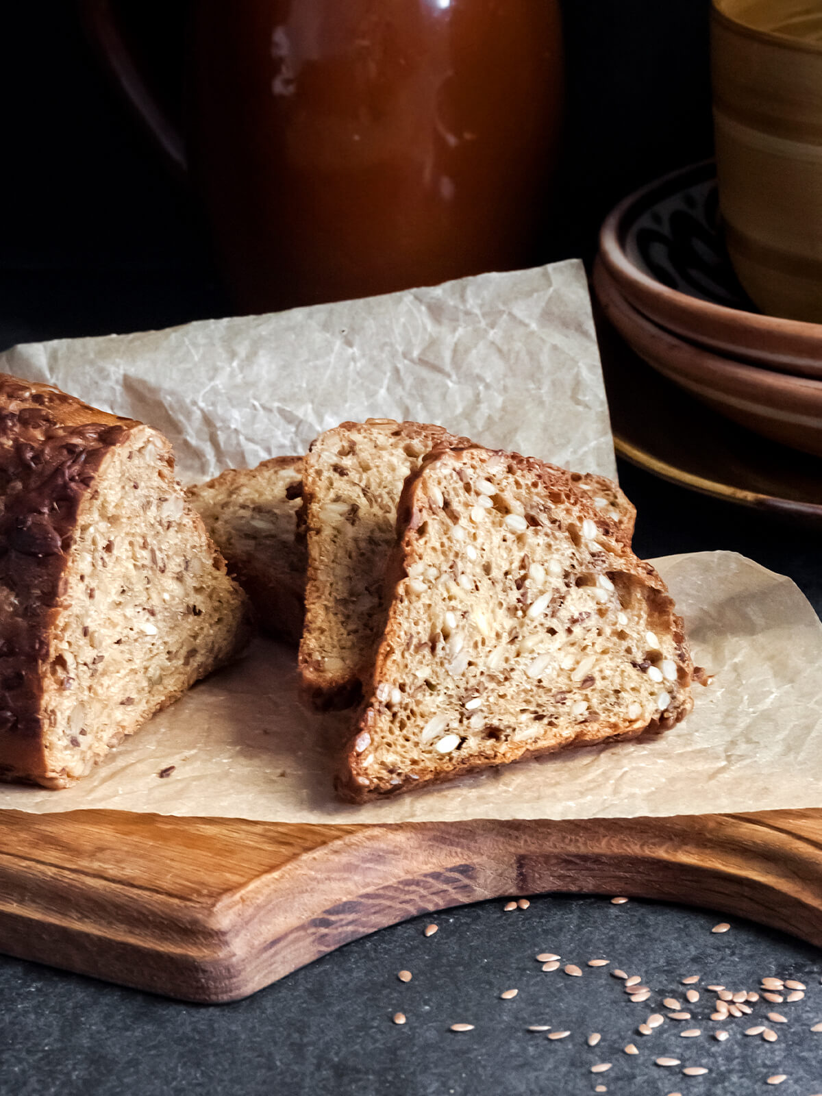 Angeschnittenes Saaten-Brot mit Sonnenblumenkernen und Leinsamen auf Holzbrett