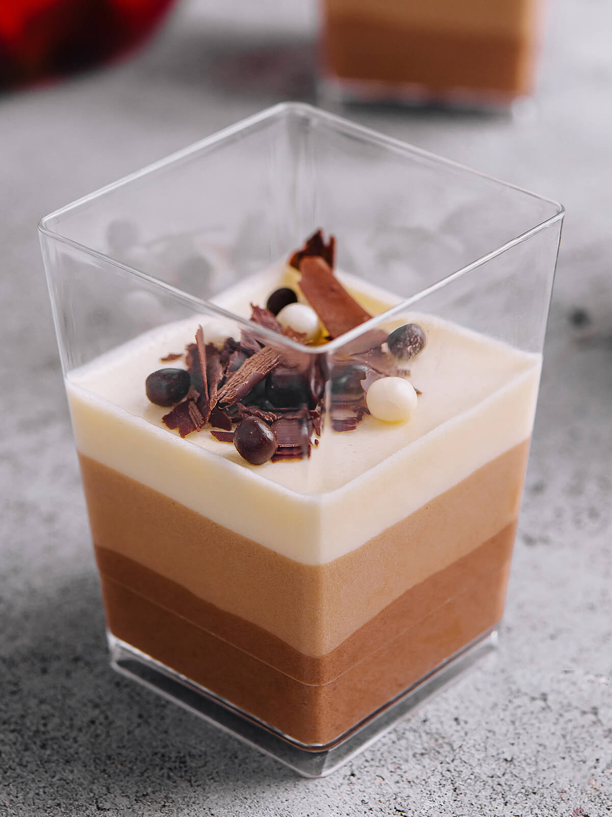 Dreierlei Schokoladenmousse mit drei sauber getrennten Schichten im eckigen Glas