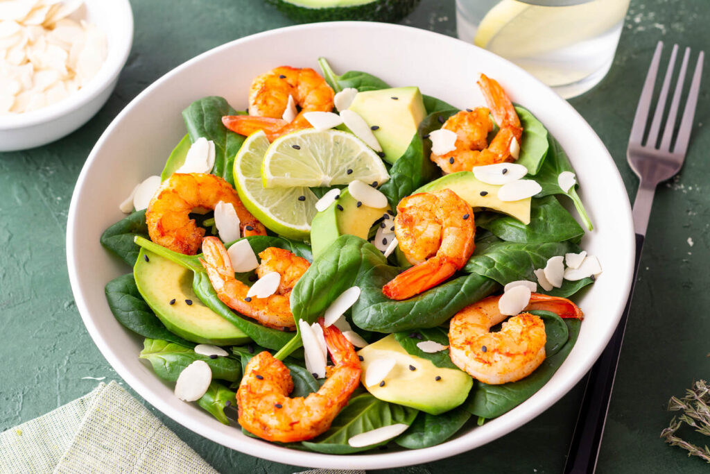 Spinat-Garnelen-Salat mit Avocado und Mandeln in Schüssel