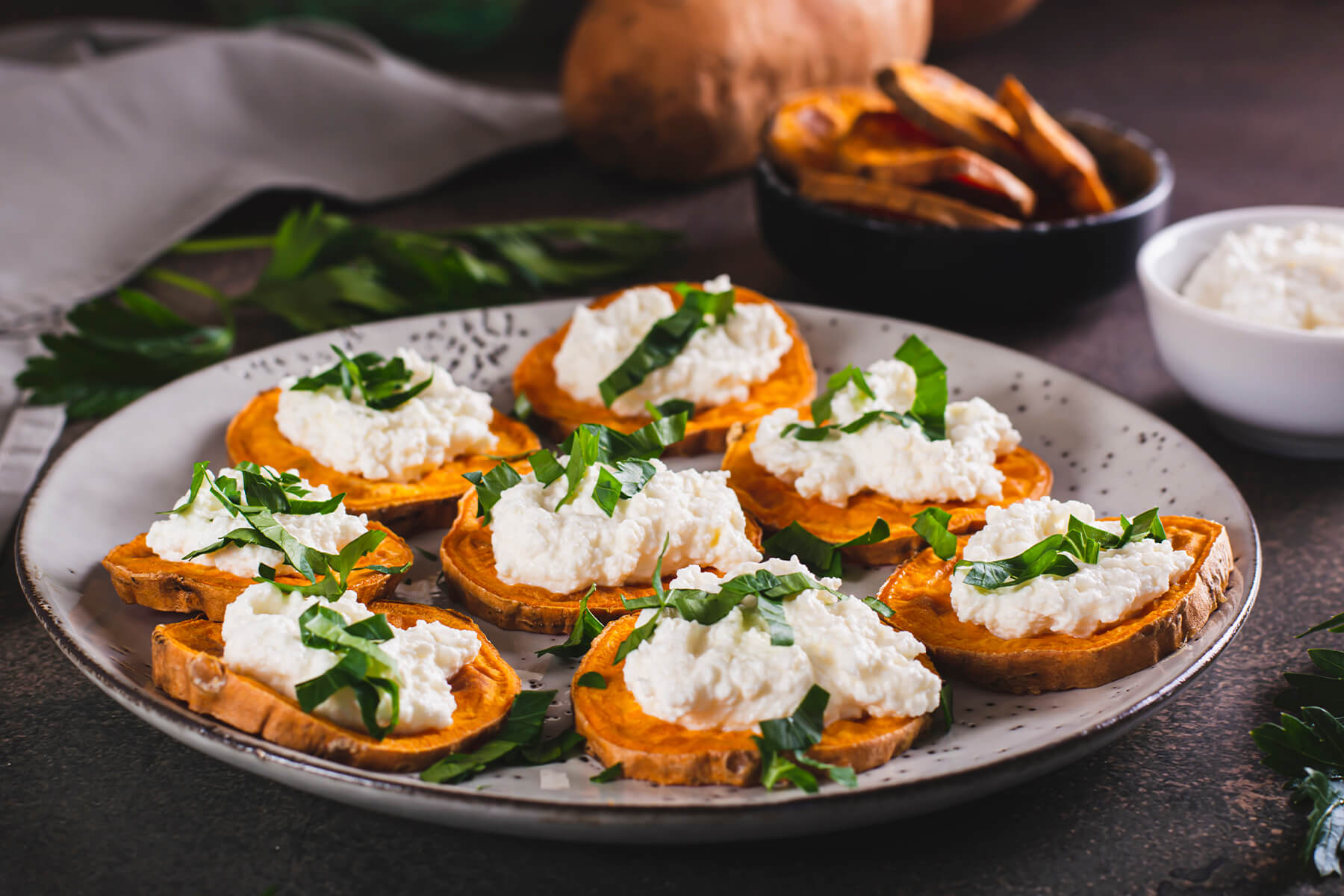 Gebackene Süßkartoffel-Taler mit Ricotta-Nocken von der Seite fotografiert