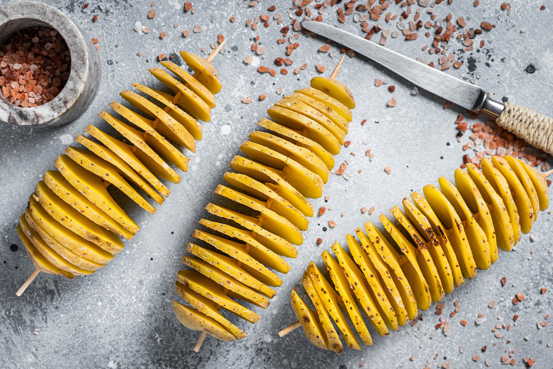 Rohe Tornado-Kartoffeln am Spieß mit aufgezogenem Spiralschnitt vor dem Backen