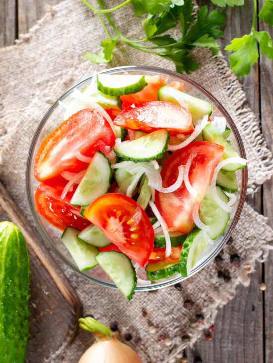 Vitamin-Salat aus Tomaten, Gurken und Zwiebeln in einer Glasschüssel